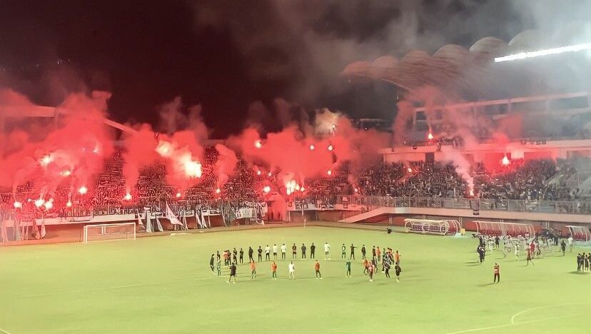 Gambar pertandingan sepak bola dengan flare